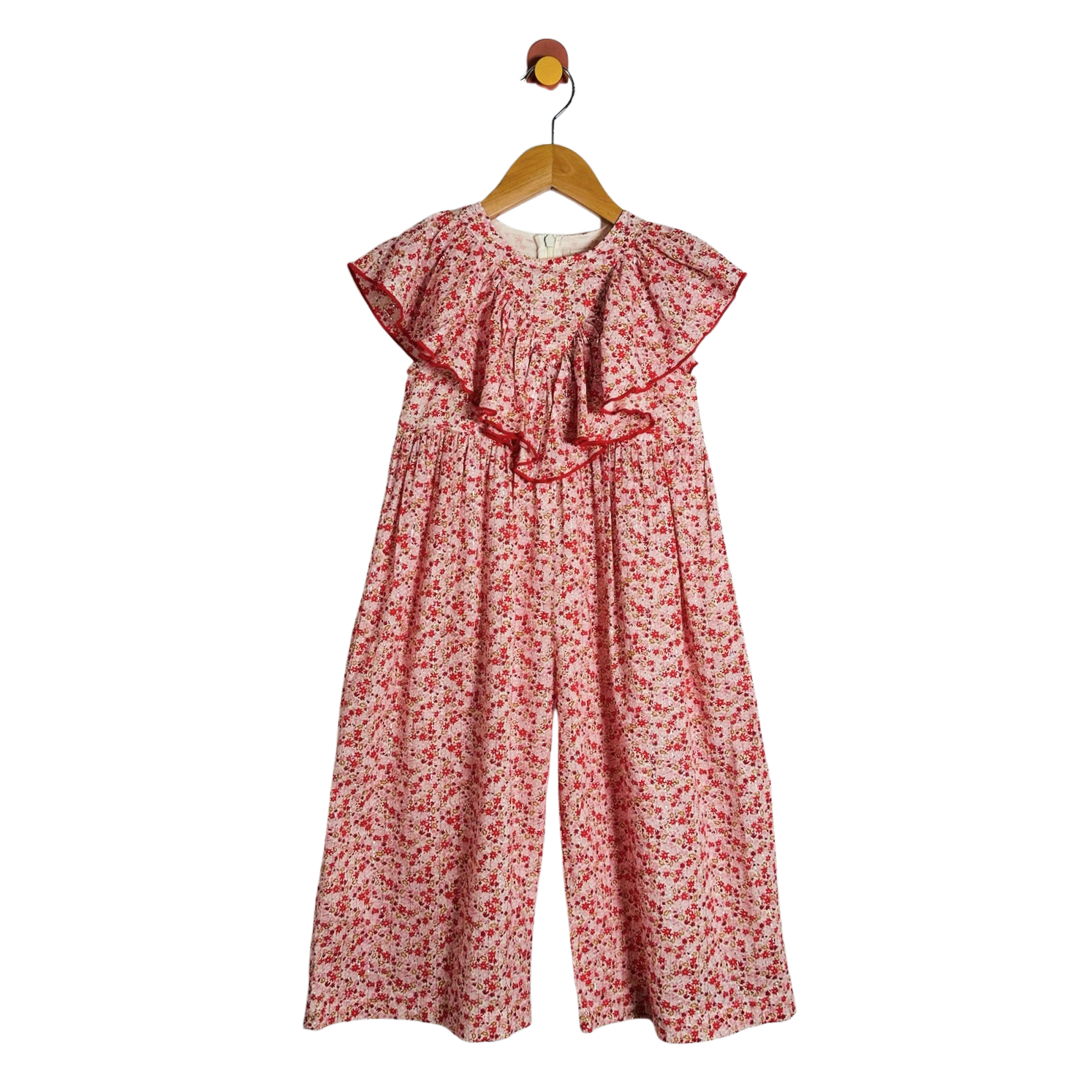 A children's floral jumpsuit with wide legs and ruffled cap sleeves, hanging on a wooden hanger against a plain white background.