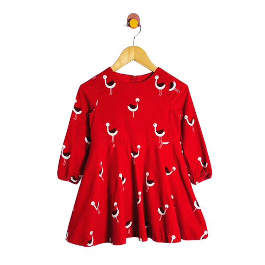 Red dress with bird pattern on a hanger against a white background