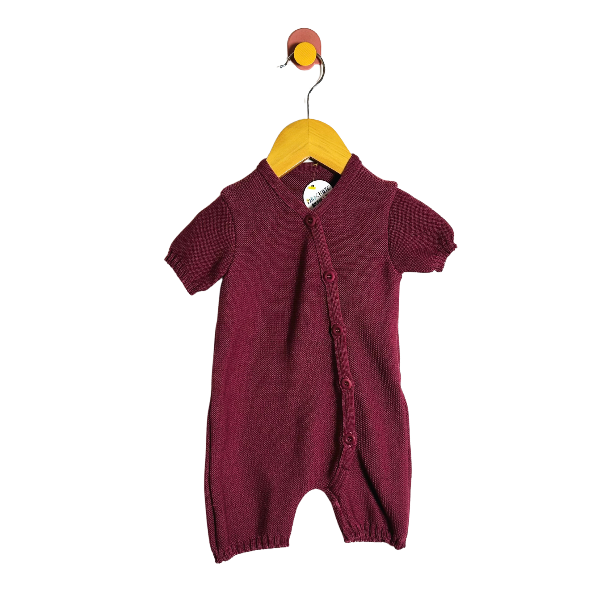 Maroon baby romper on a hanger against a white background