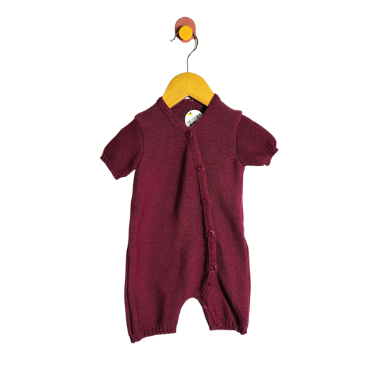 Maroon baby romper on a hanger against a white background