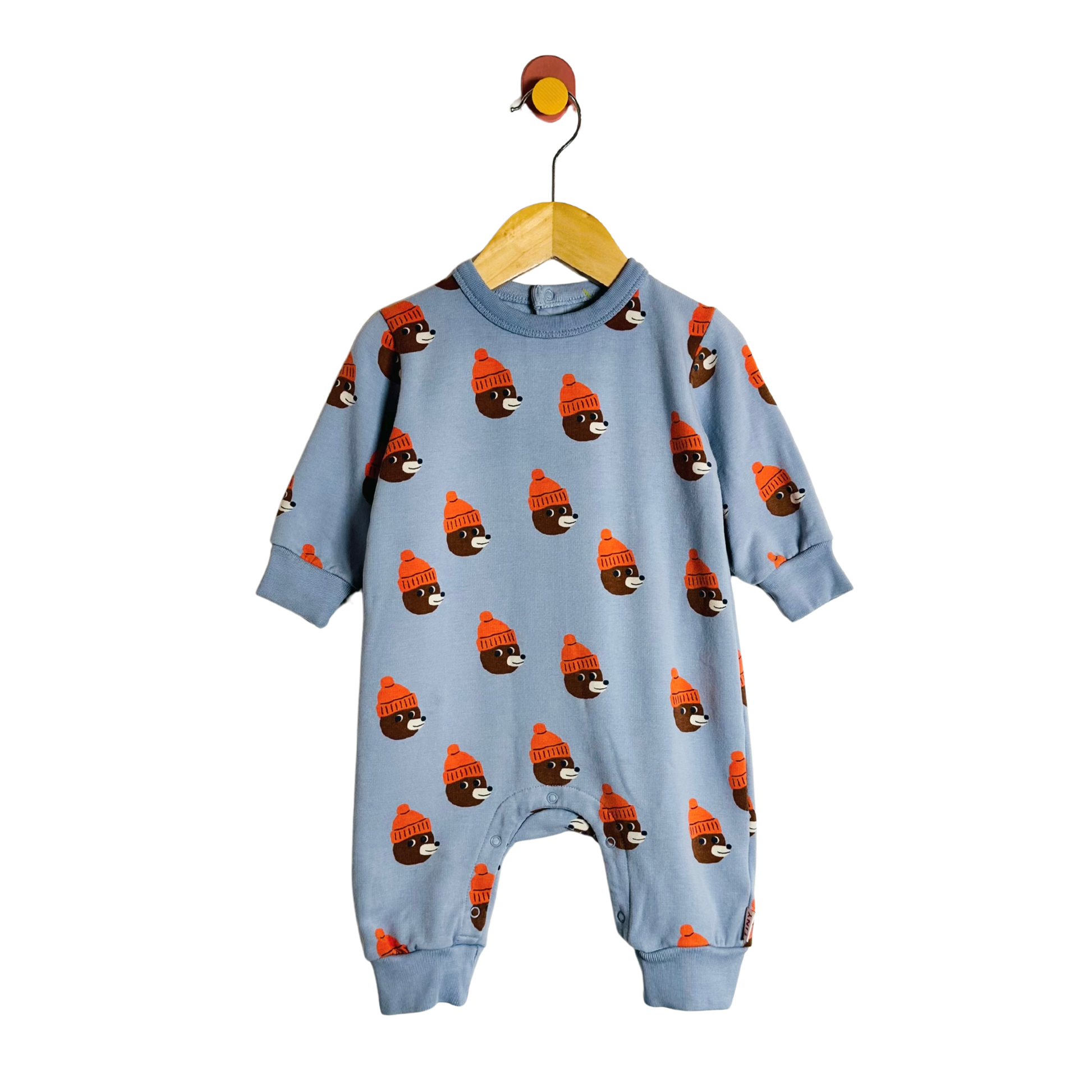 Blue baby onesie with bear pattern on a hanger against a white background