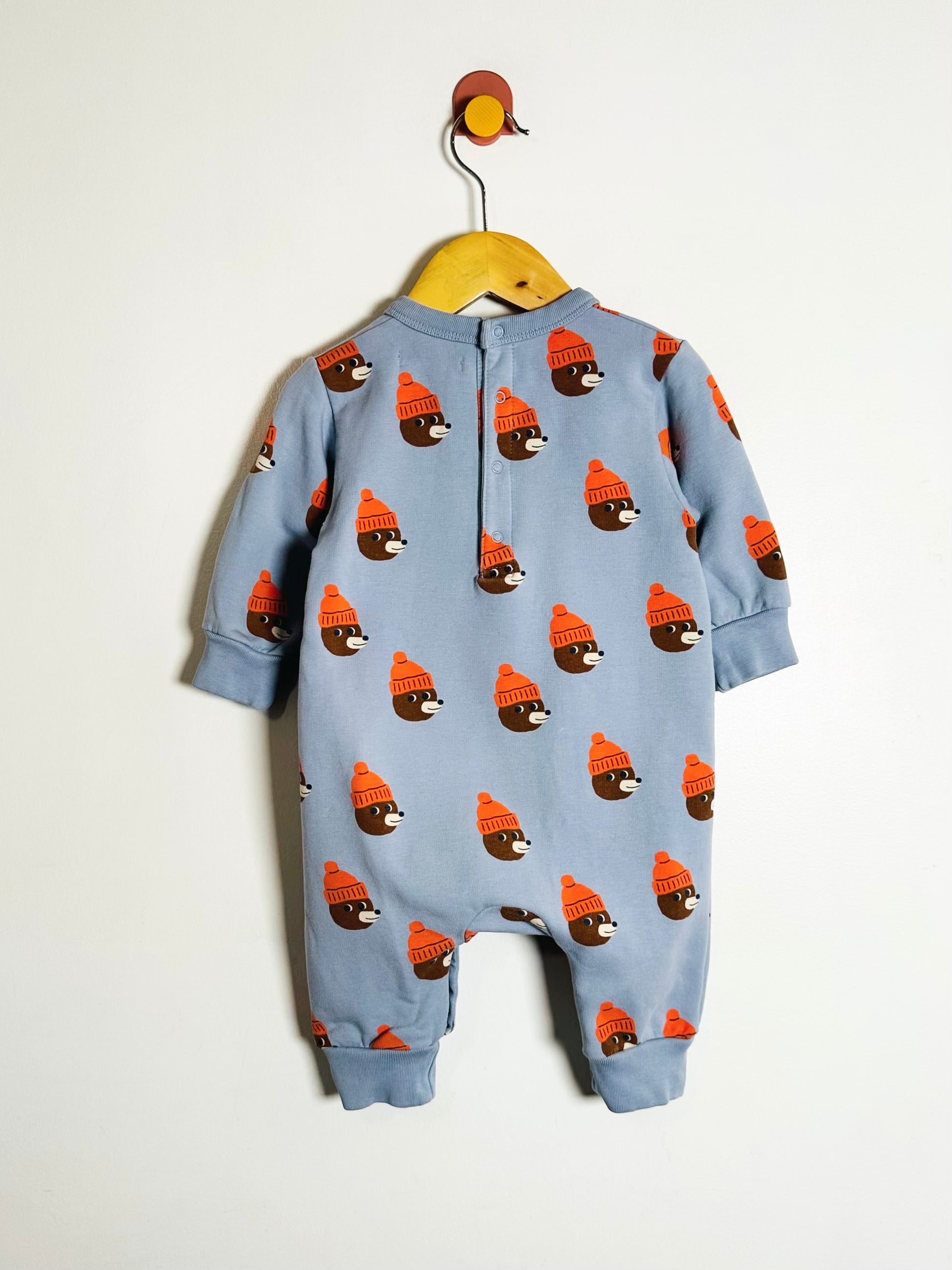 Blue baby onesie with bear pattern on a white background