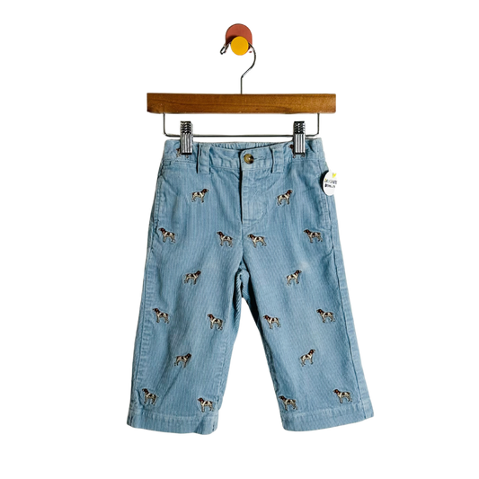 Light blue denim pants with dog pattern on a hanger against a white background