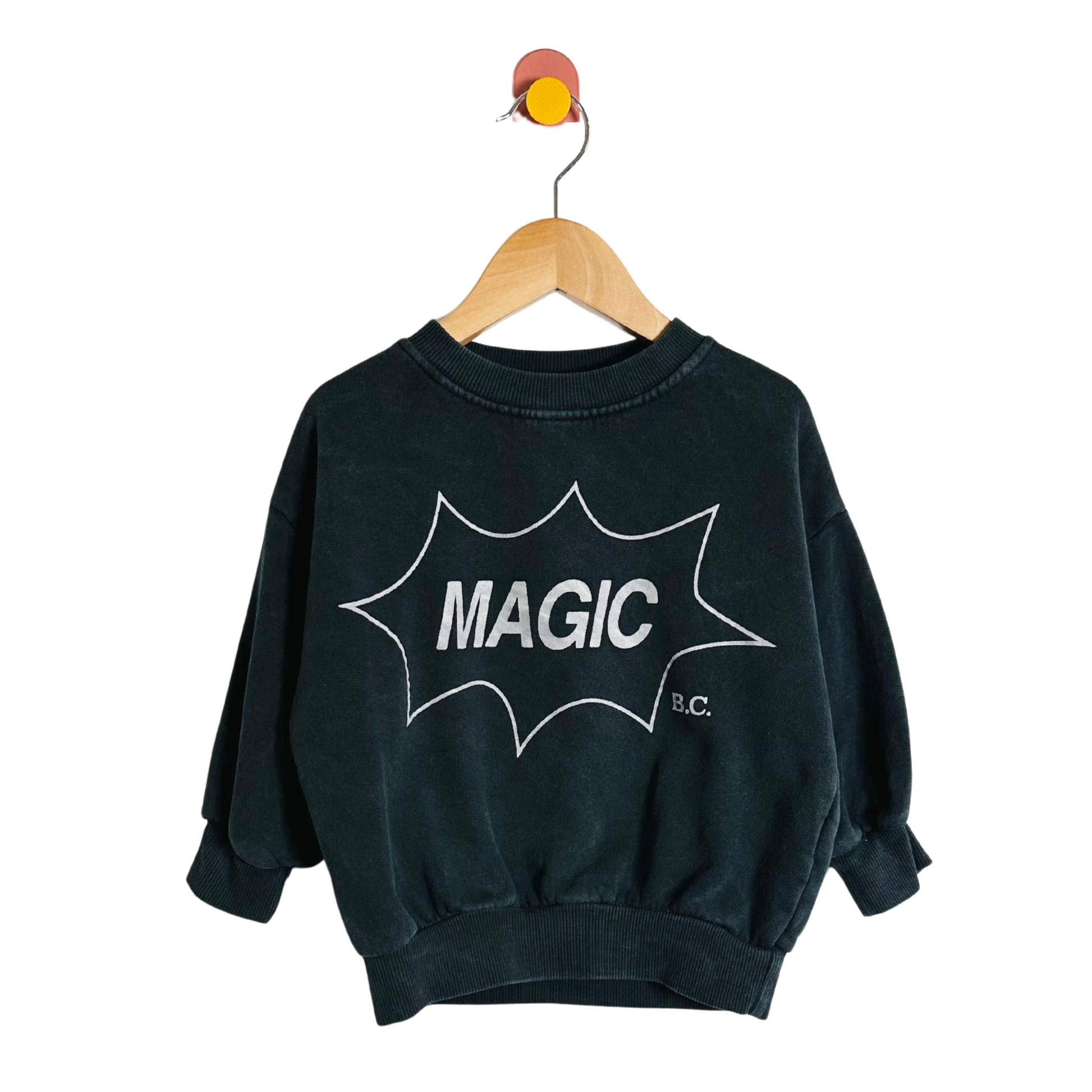 Black sweatshirt with 'MAGIC B.C.' print on a hanger against a white background
