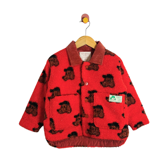 Red children's jacket with dog pattern on a hanger against a white background