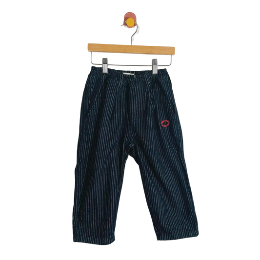 Blue striped pants on a hanger against a white background