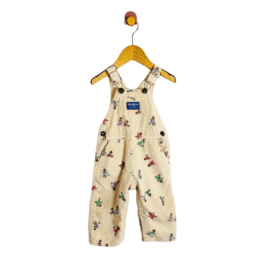 Beige children's overalls with colorful patterns on a hanger against a white background