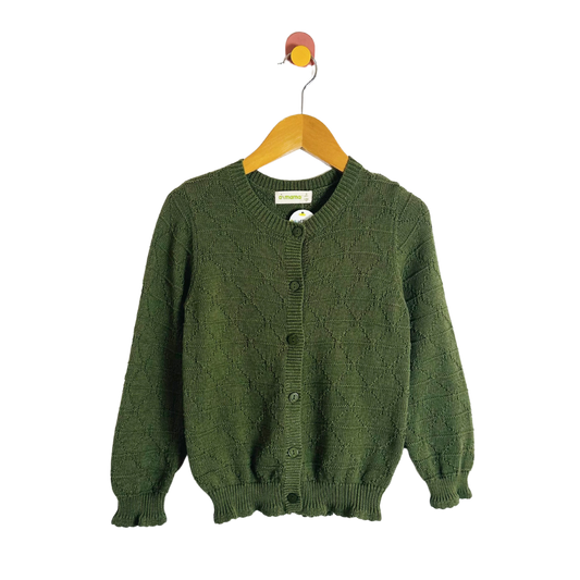 Green knitted cardigan on a wooden hanger against a white background