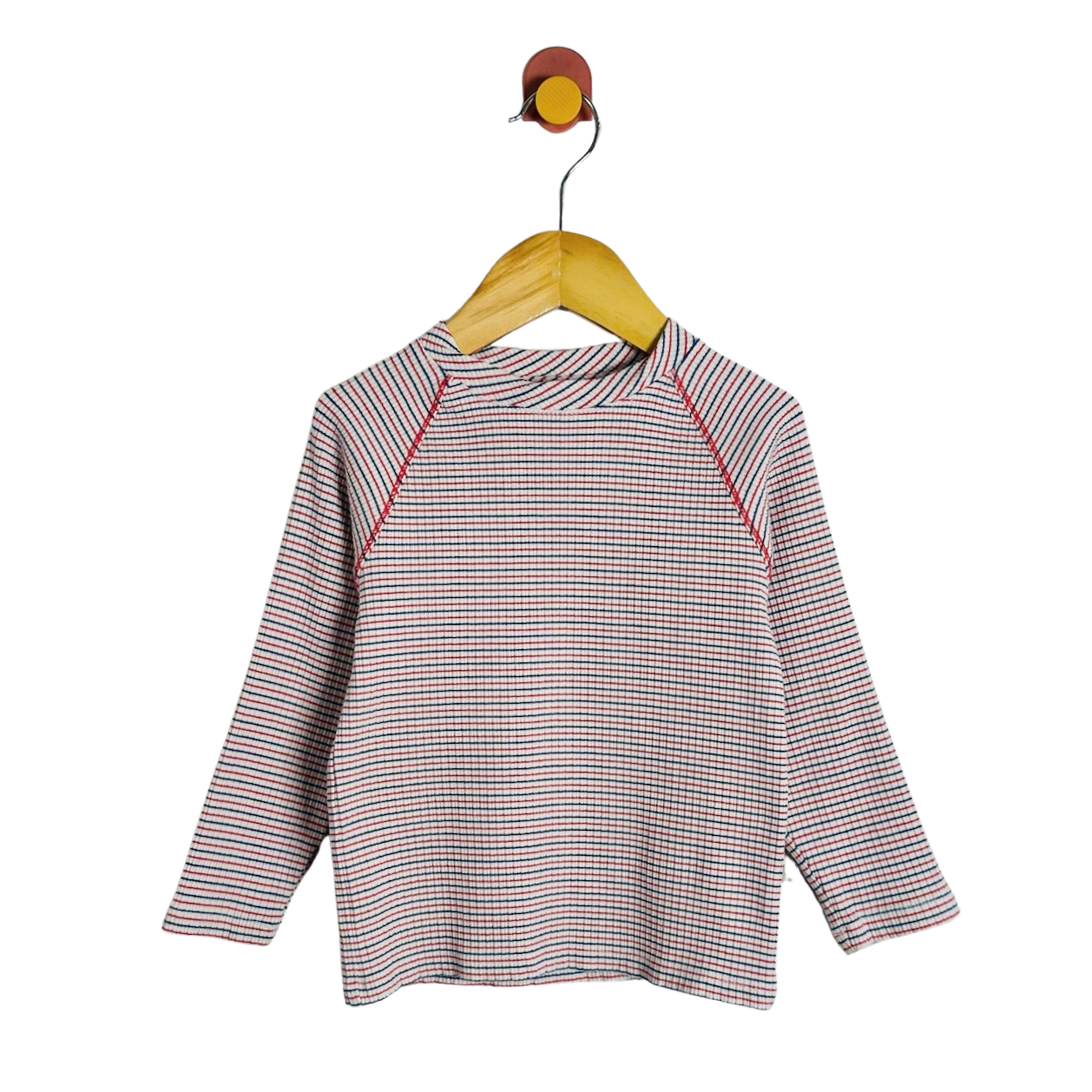 A long-sleeve raglan top with a fine red, blue, and white stripe pattern, hanging on a wooden hanger against a plain white background.