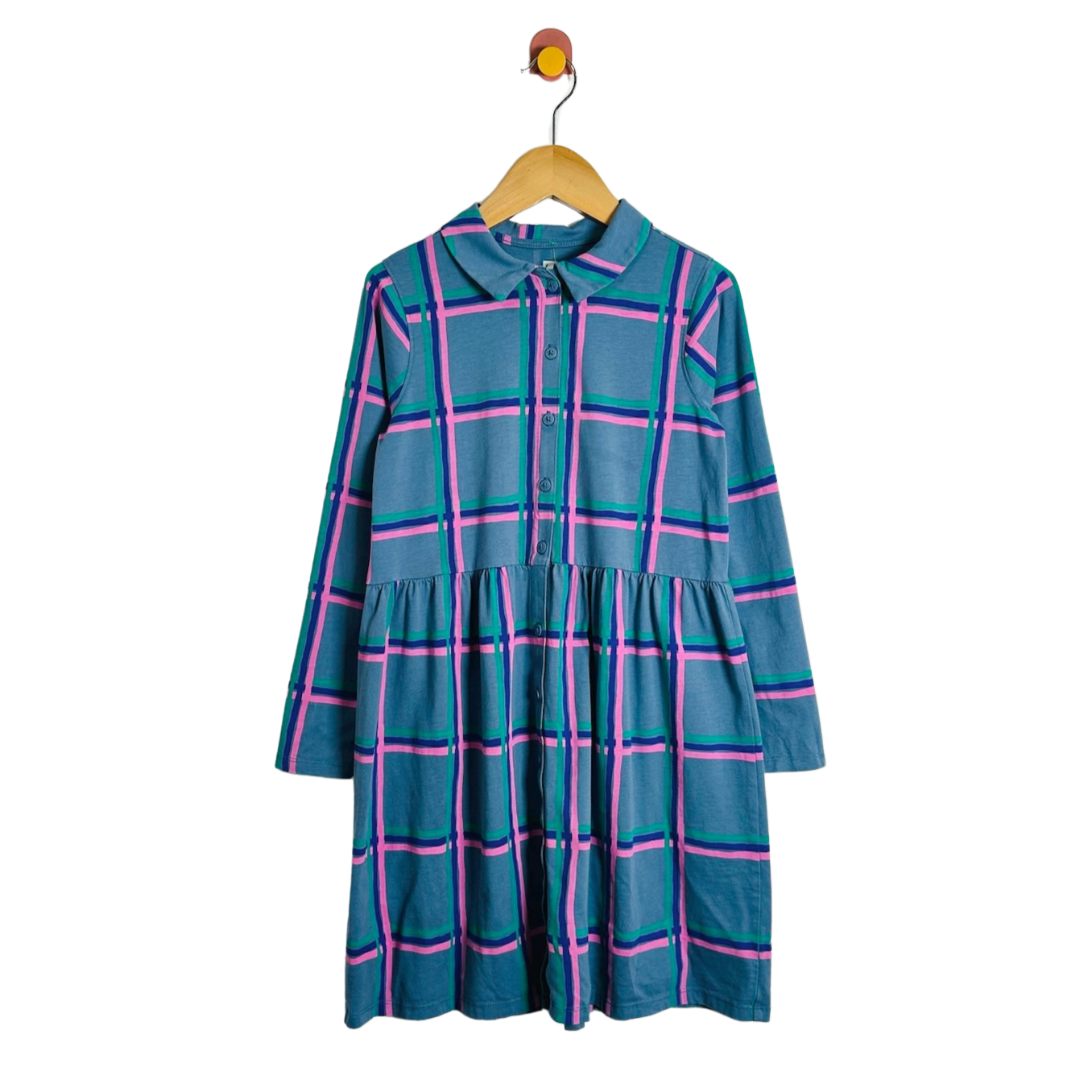 A long-sleeve plaid dress in teal blue with pink and green stripes, hanging on a wooden hanger against a plain white background.