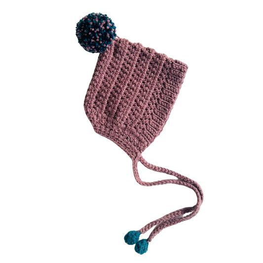 Pink knitted hat with blue pom-poms on a white background