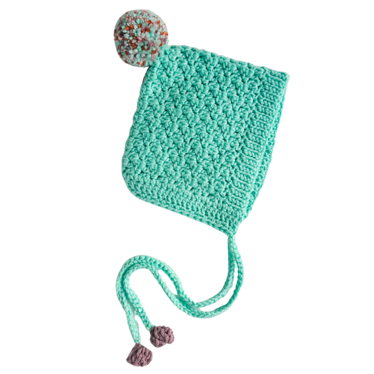 Teal knitted hat with pom-poms on a white background