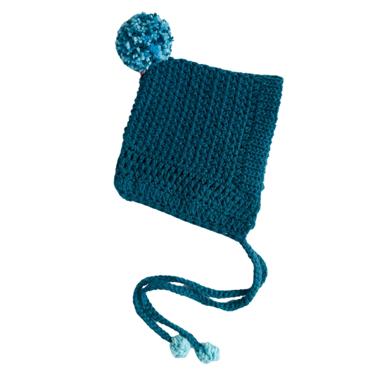 Blue knitted hat with a pom-pom on a white background