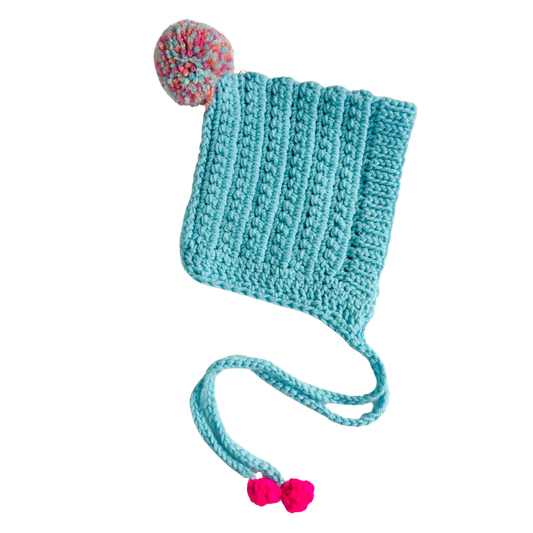 Knitted turquoise hat with pink pom-poms on a white background