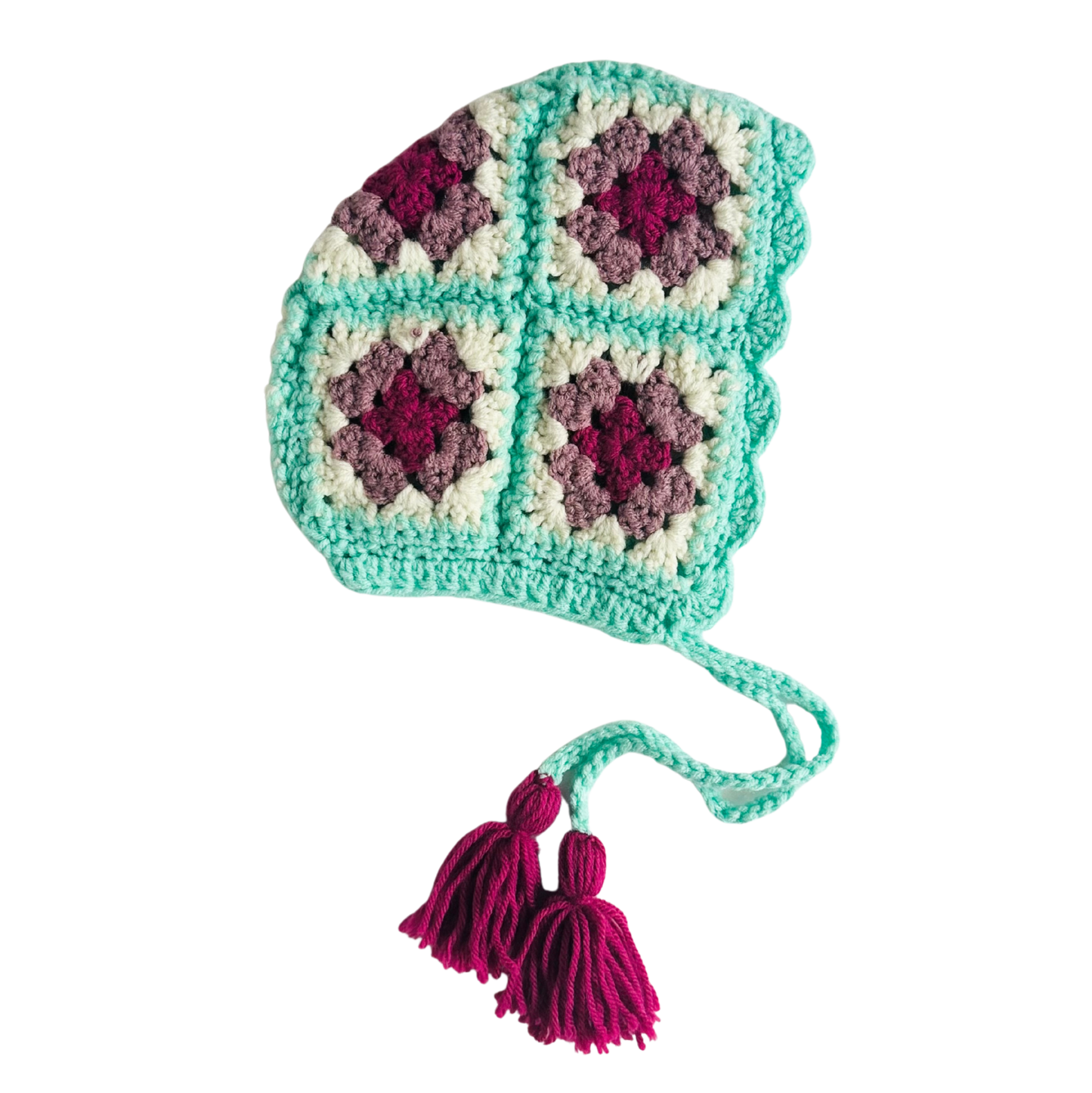 Crocheted hat with a pattern and tassels on a white background