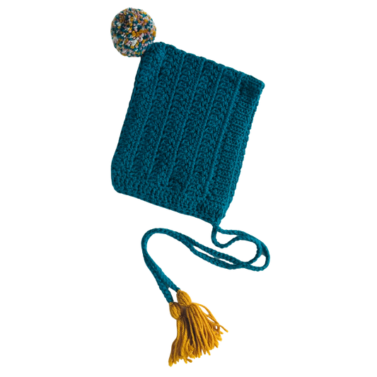 Blue knitted bonnet with a yellow tassel on a white background