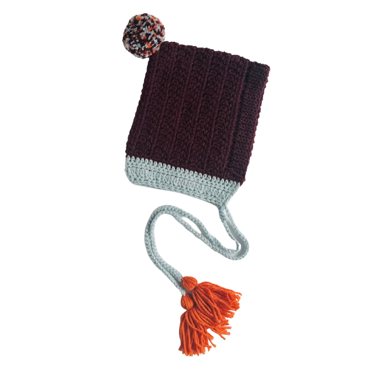 Knitted hat with pom-pom and tassel on a white background