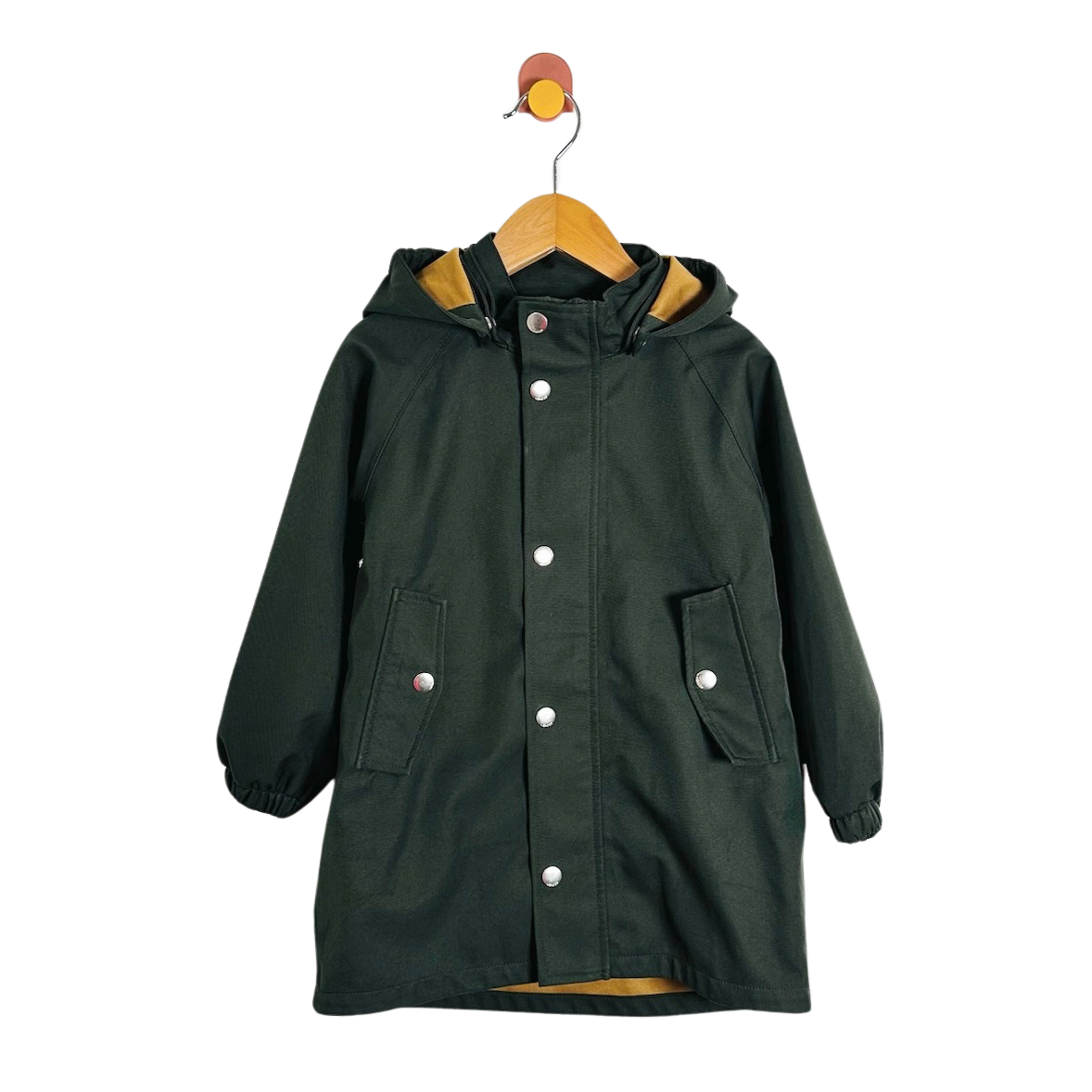 A dark forest green hooded raincoat with silver snap buttons, displayed on a wooden hanger against a plain white background.