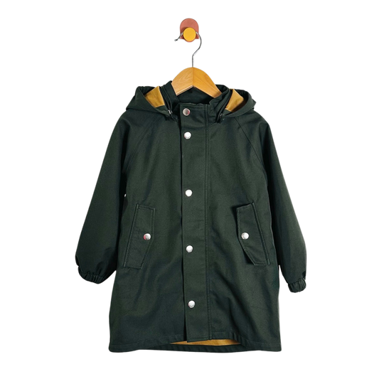 A dark forest green hooded raincoat with silver snap buttons, displayed on a wooden hanger against a plain white background.