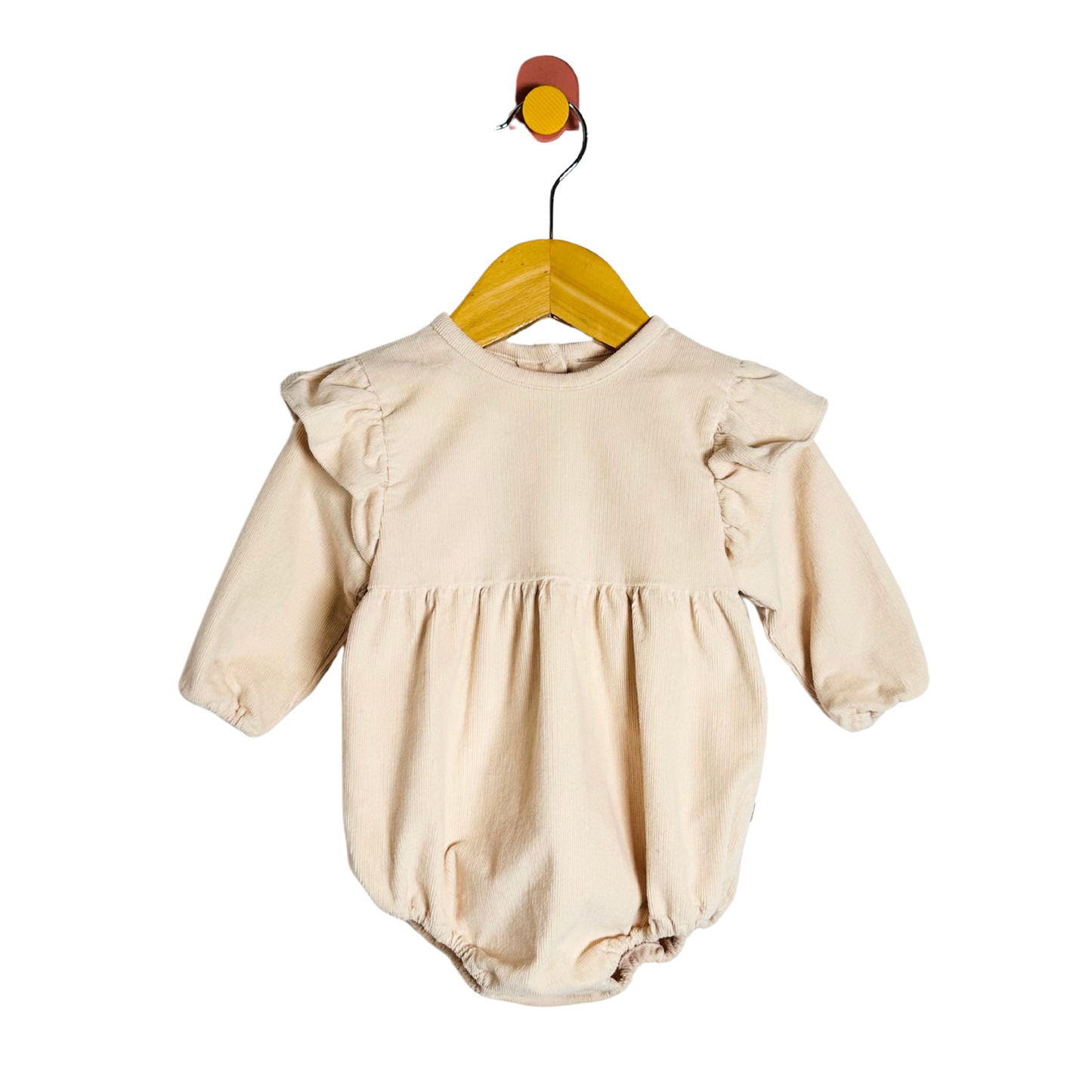 Beige baby romper on a wooden hanger against a white background