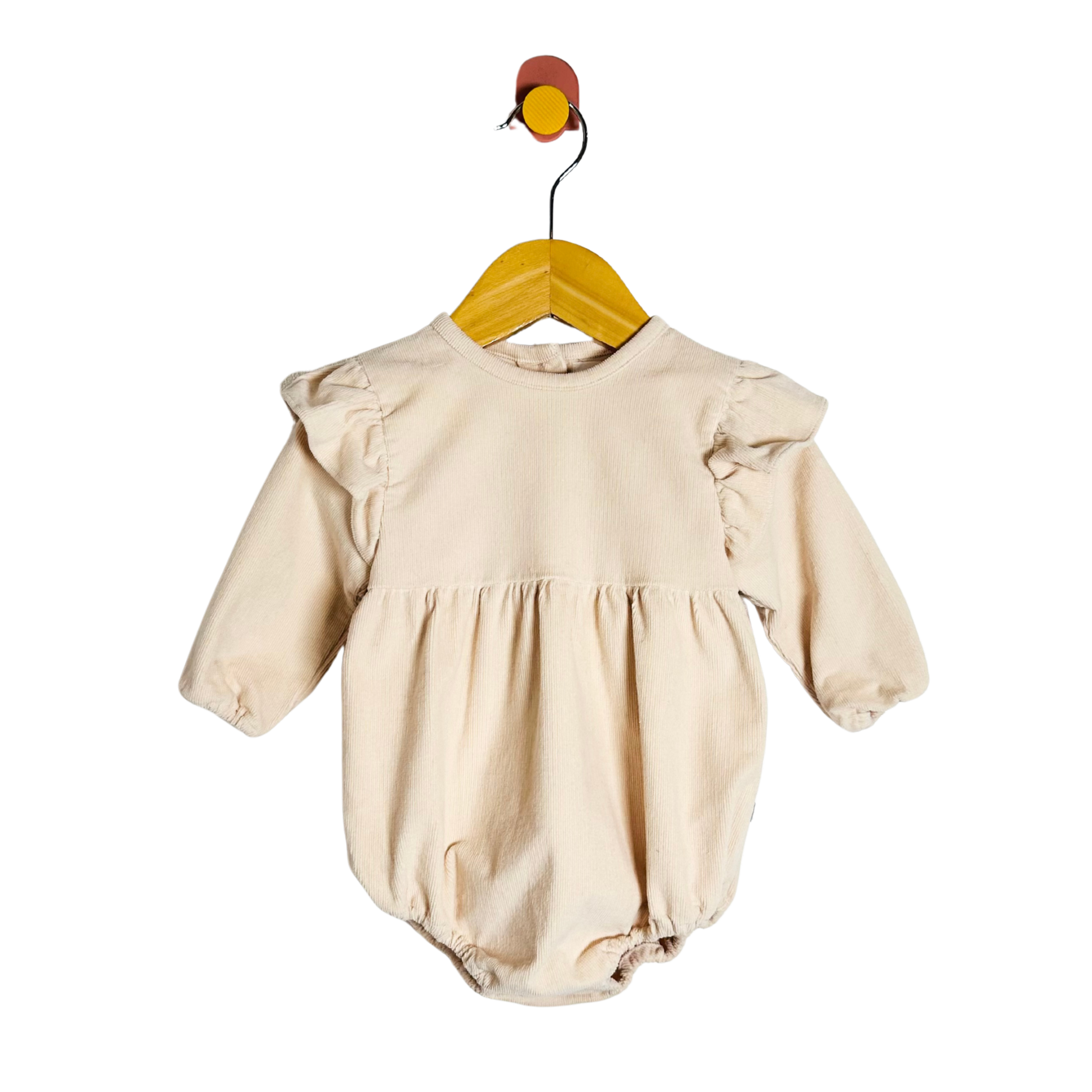 Beige baby romper on a wooden hanger against a white background