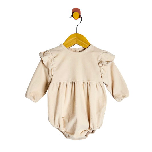 Beige baby romper on a wooden hanger against a white background