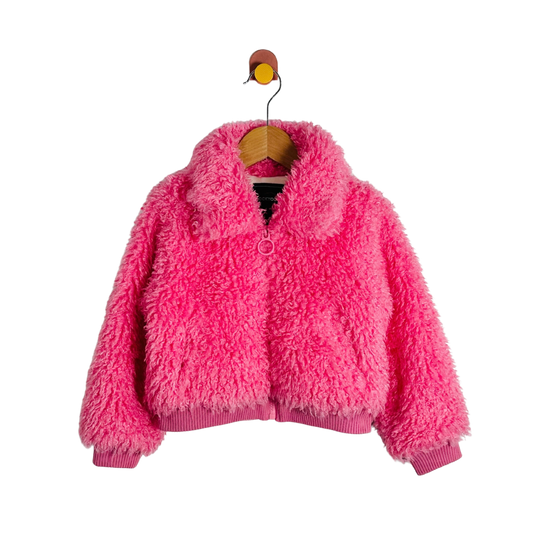 A bright pink fuzzy sherpa jacket with a ribbed collar, cuffs, and hem, hanging on a wooden hanger against a plain white background.