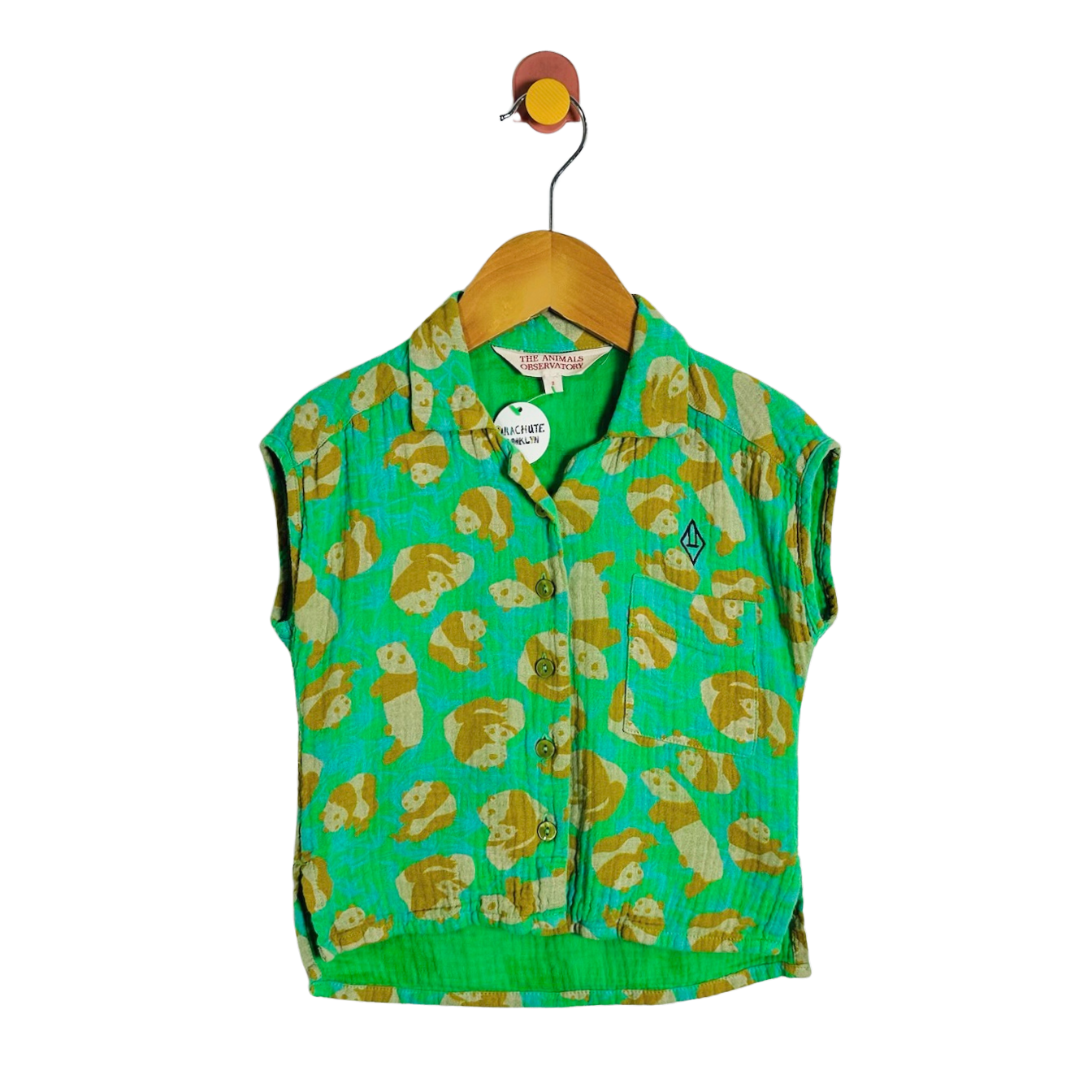A green sleeveless button-front vest with an allover tan and cream panda print, hanging on a wooden hanger against a plain white background.