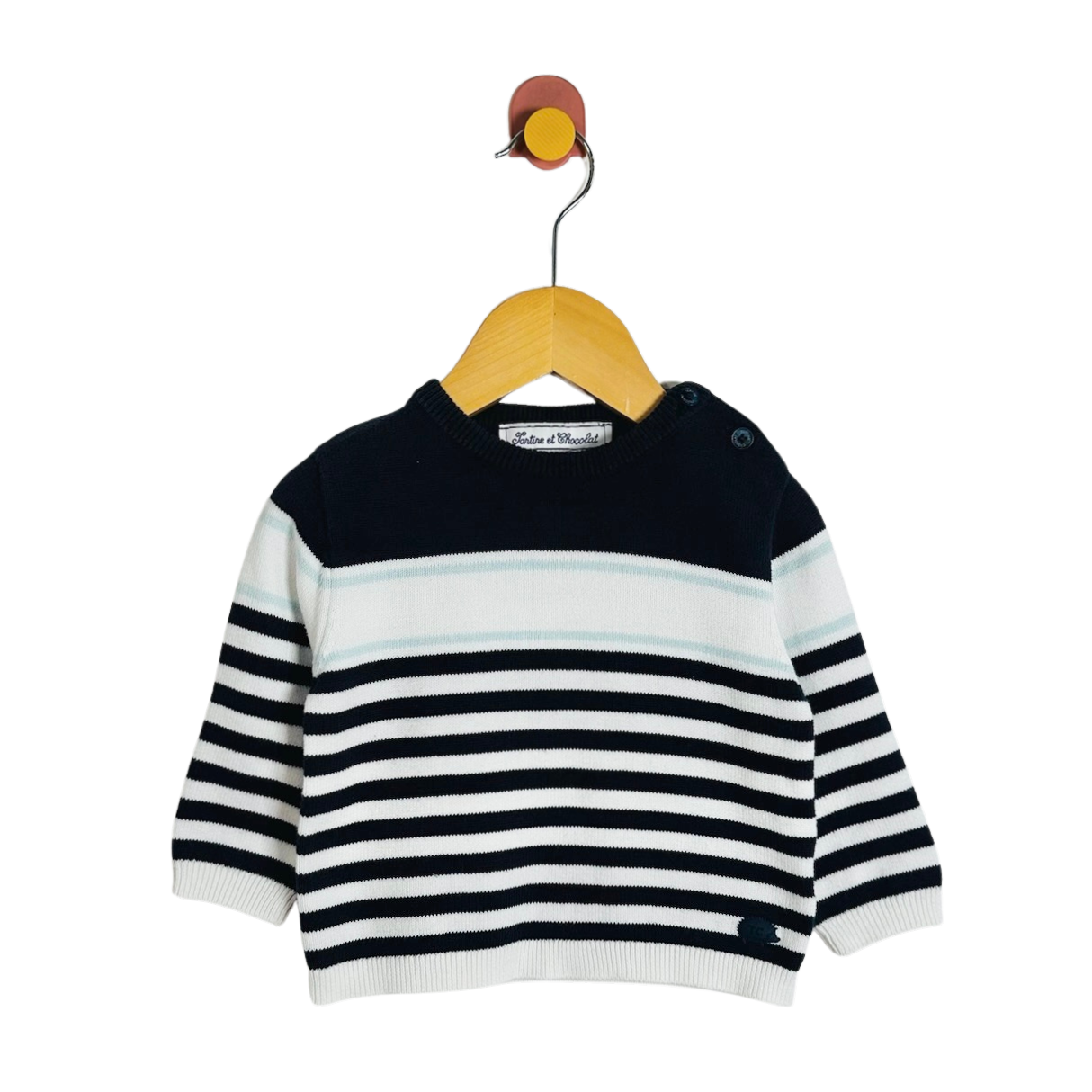 A baby knit sweater with horizontal navy and white stripes, hanging on a wooden hanger against a plain white background.