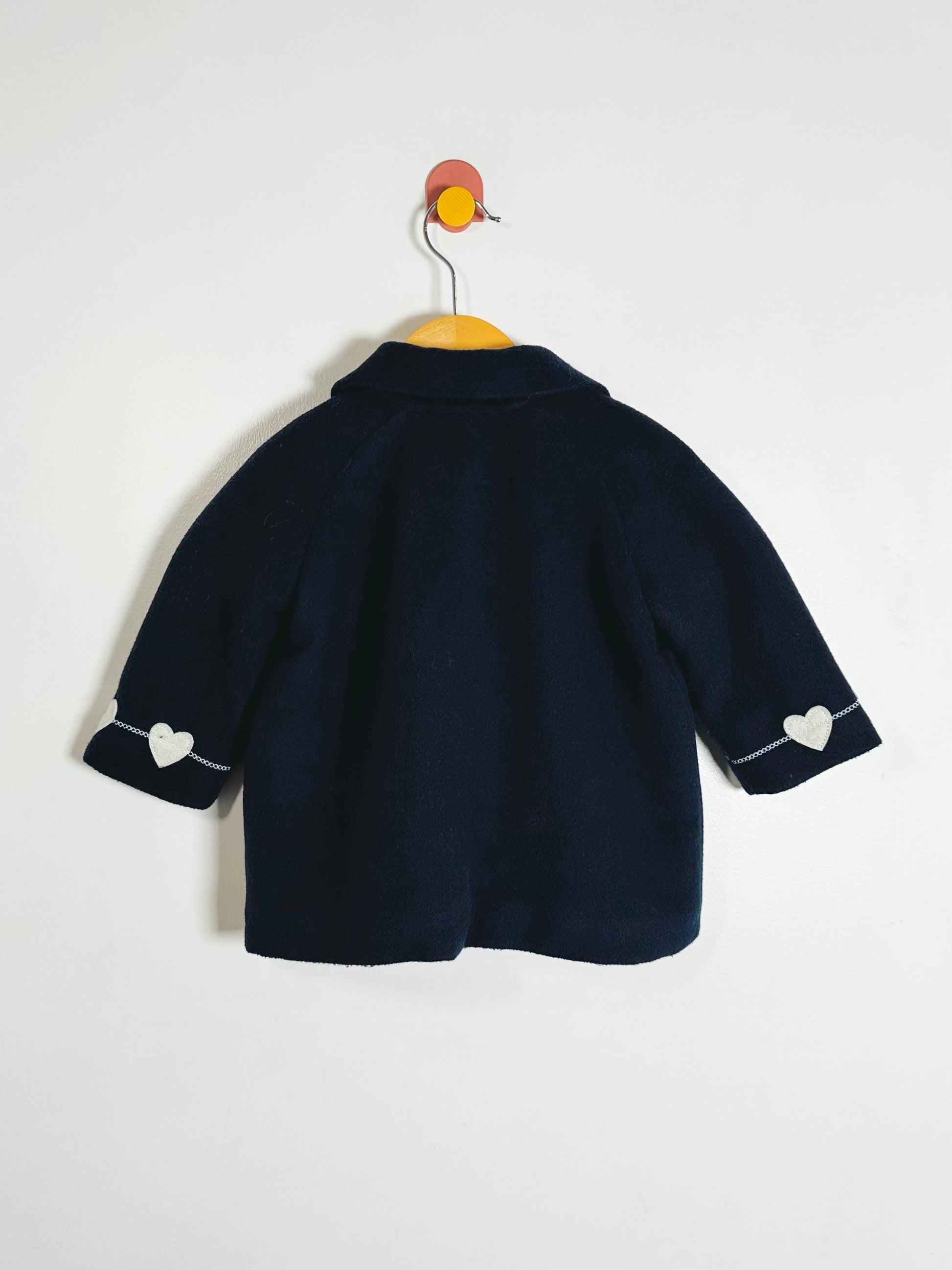 Navy blue children's jacket with heart details on a white background