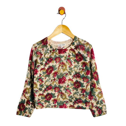 Floral-patterned sweater on a hanger against a white background