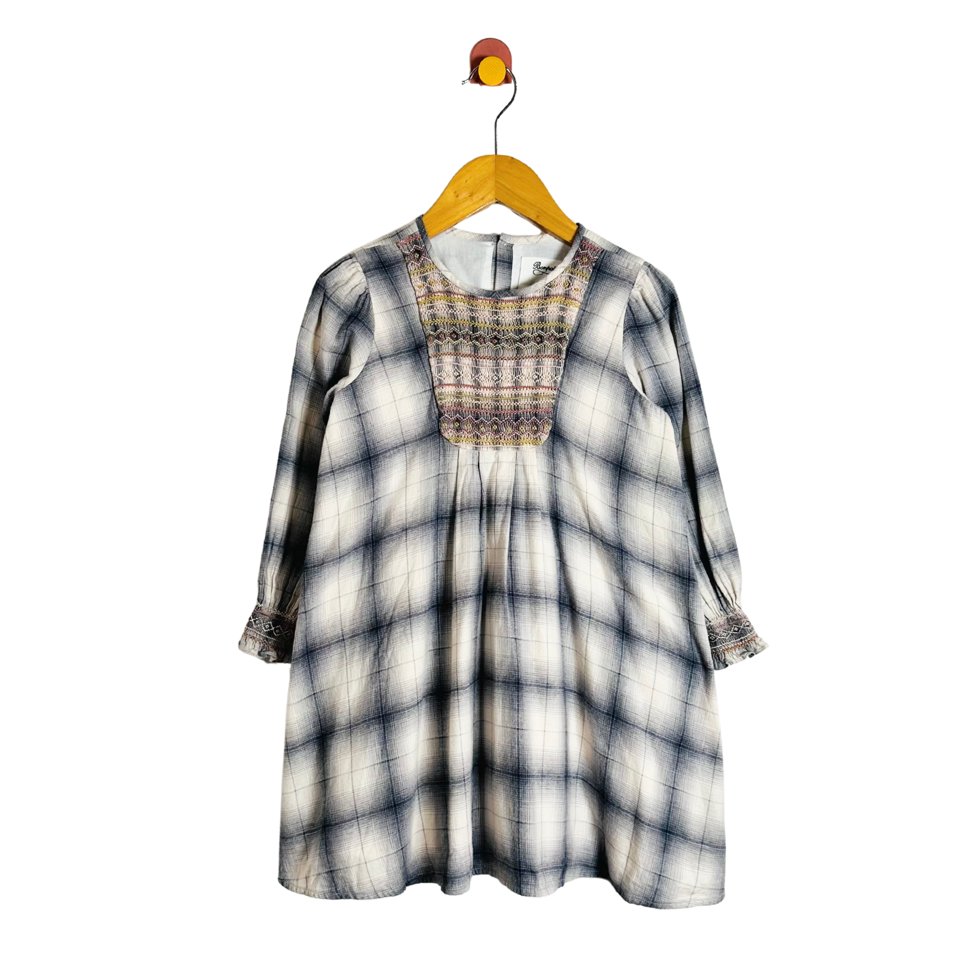 Plaid dress on a hanger against a white background