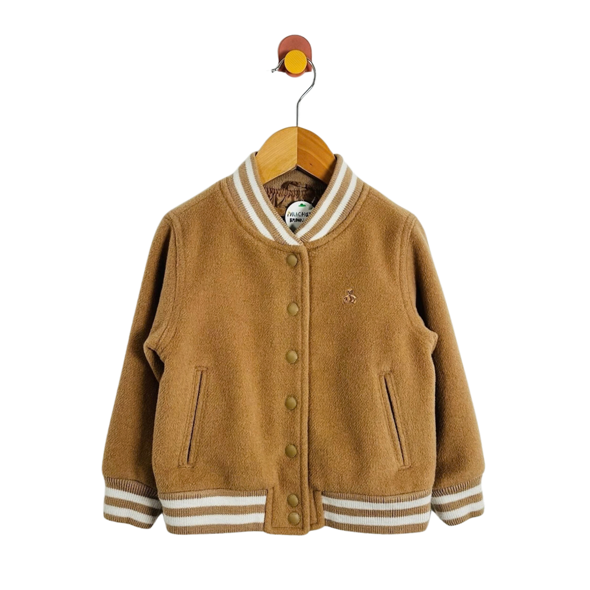 A toddler's brown wool-blend varsity jacket with cream striped ribbed collar, cuffs, and hem, hanging on a wooden hanger against a white background.