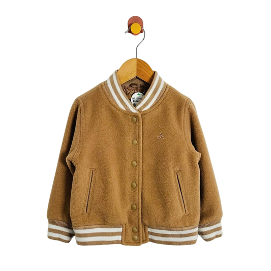 A toddler's brown wool-blend varsity jacket with cream striped ribbed collar, cuffs, and hem, hanging on a wooden hanger against a white background.