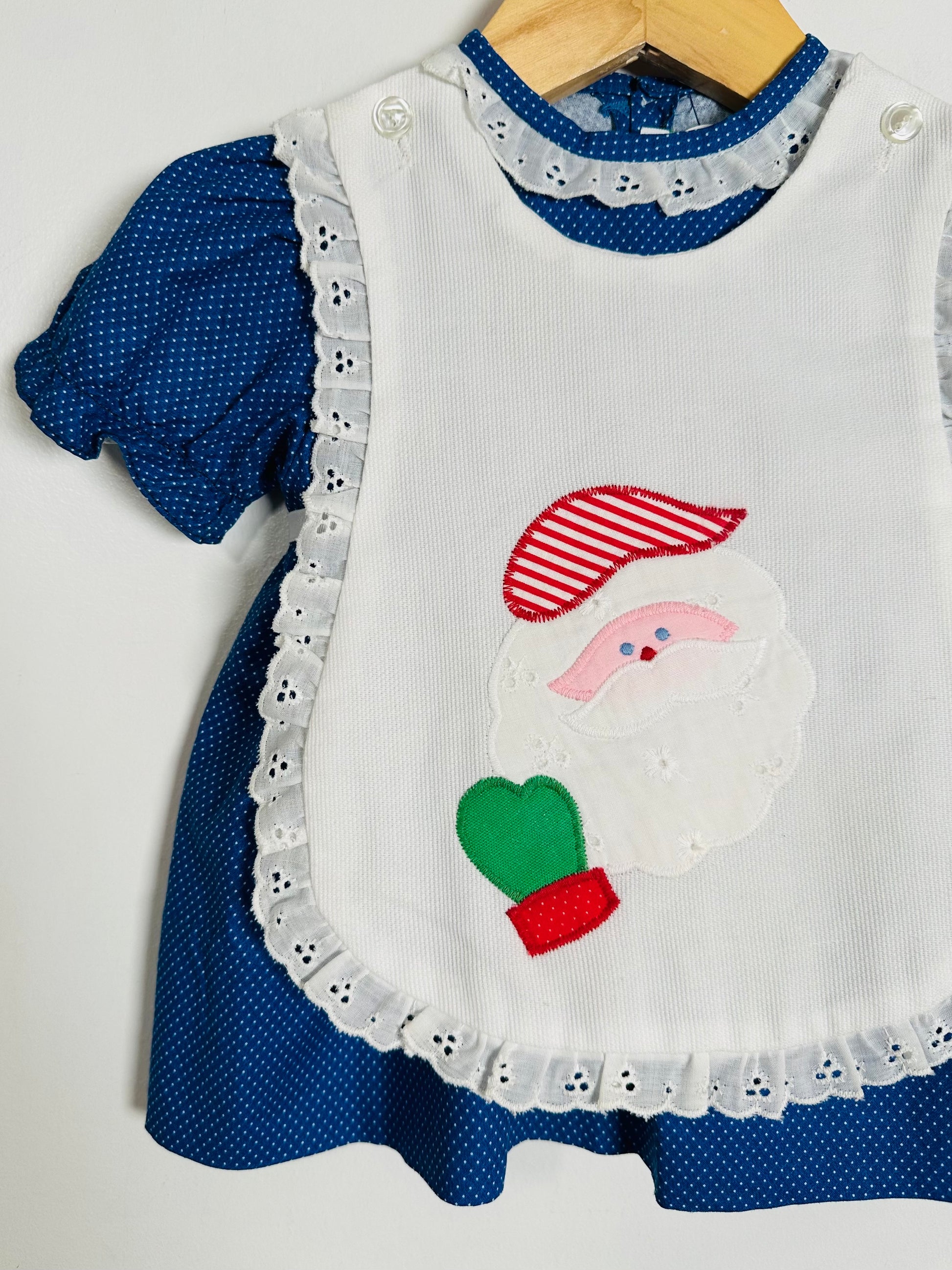 Children's dress with bib featuring a Santa Claus design on a white background