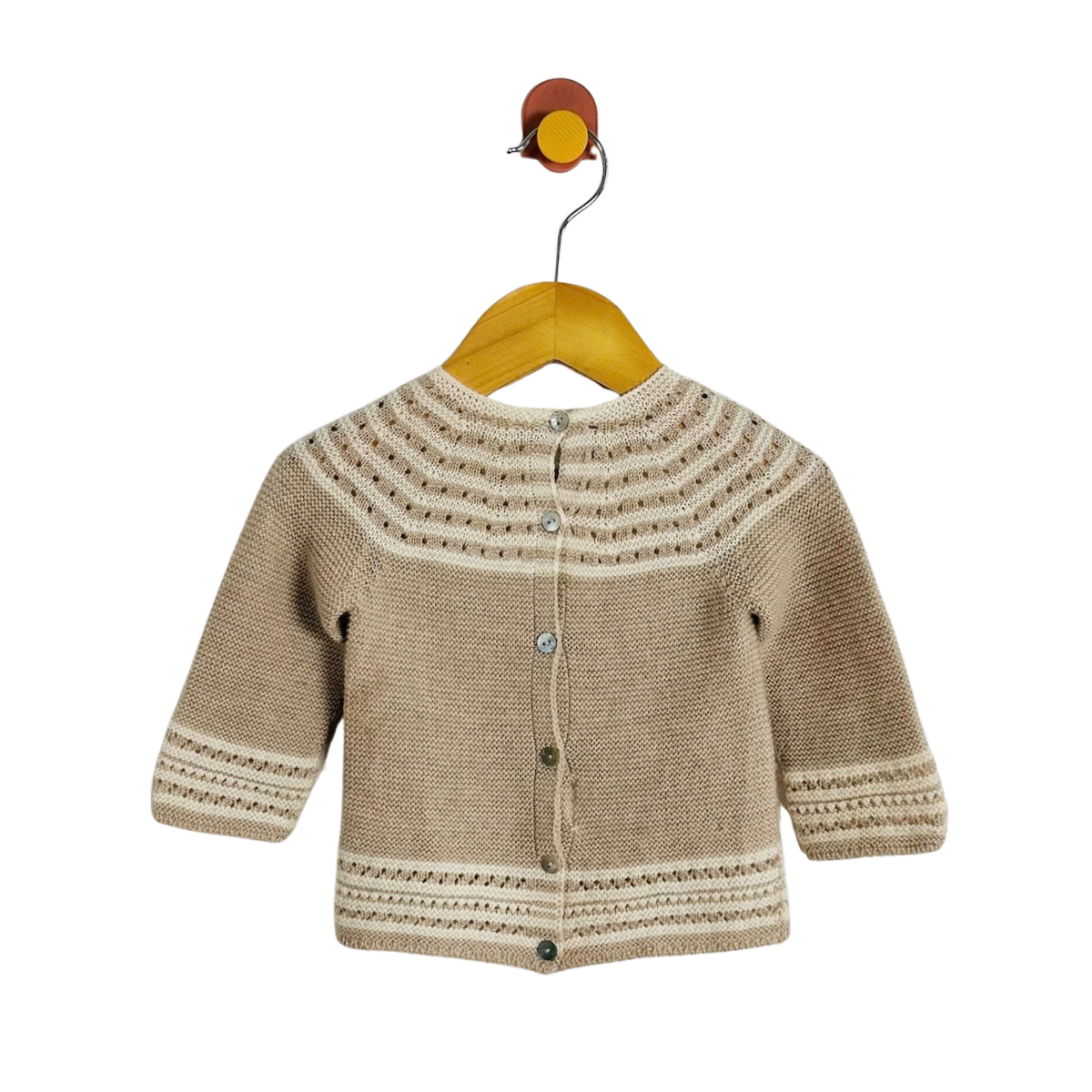 A beige knit cardigan sweater with cream-colored geometric patterns on the yoke, cuffs, and hem, hanging on a wooden hanger against a solid white background.
