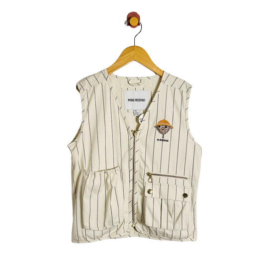 A sleeveless cream-colored pinstripe vest with a small cartoon character patch on the left chest, hanging on a wooden hanger against a white background.