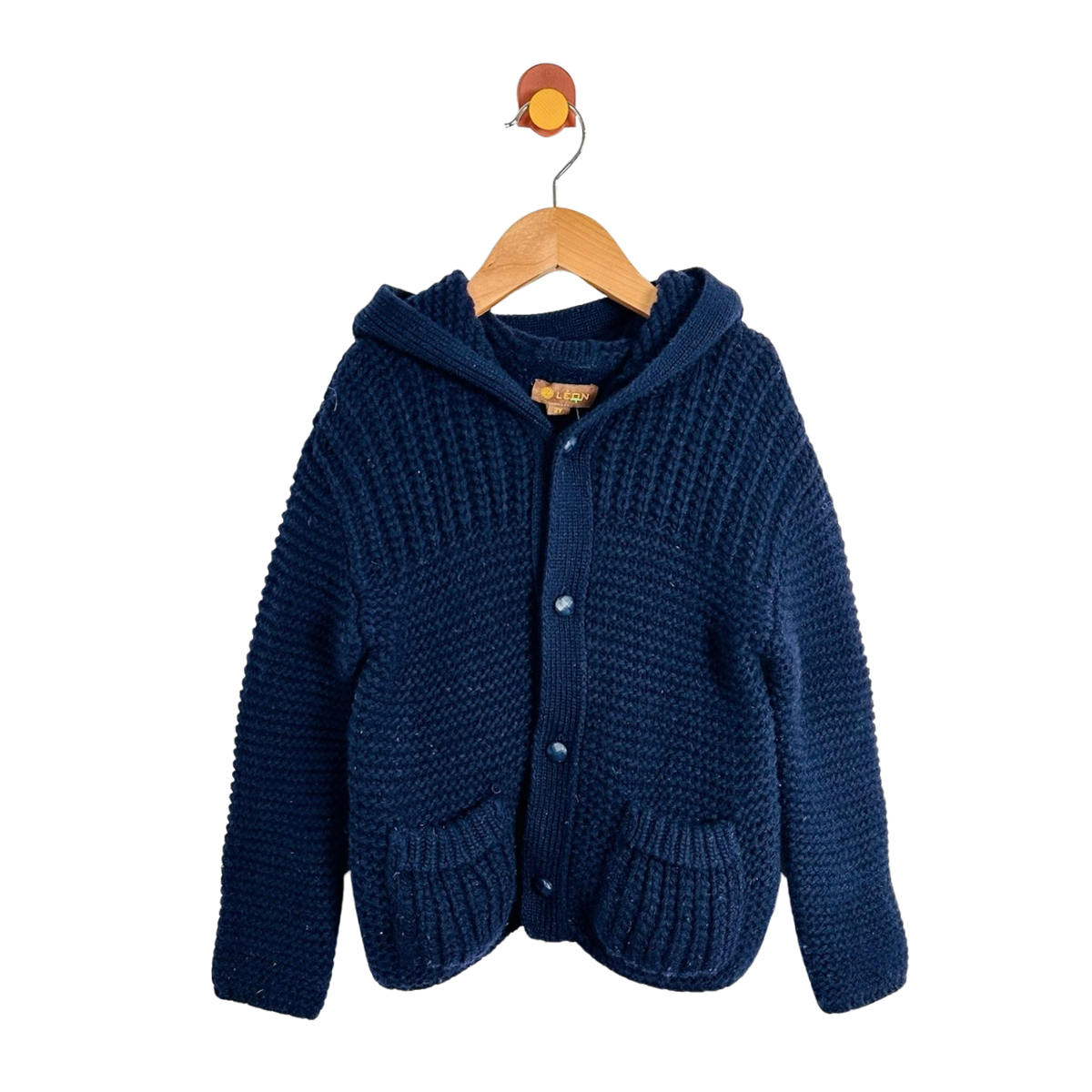 A navy blue chunky knit hooded cardigan sweater with front buttons and pockets, hanging on a wooden hanger against a plain white background.