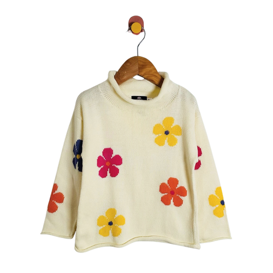 Cream-colored knit sweater with colorful floral patterns, hanging on a wooden hanger against a white background.