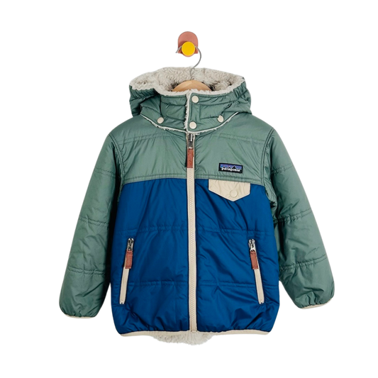 A Patagonia kids' puffer jacket in sage green and blue, featuring a hood, faux-fur lining, and a front zipper, shown hanging on a wooden hanger against a white background.