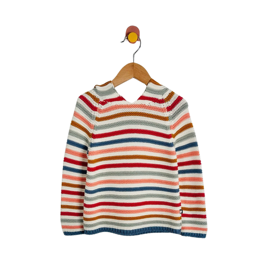 A children's knit sweater with horizontal stripes in red, orange, brown, blue, pink, and cream, hanging on a wooden hanger against a plain white background.