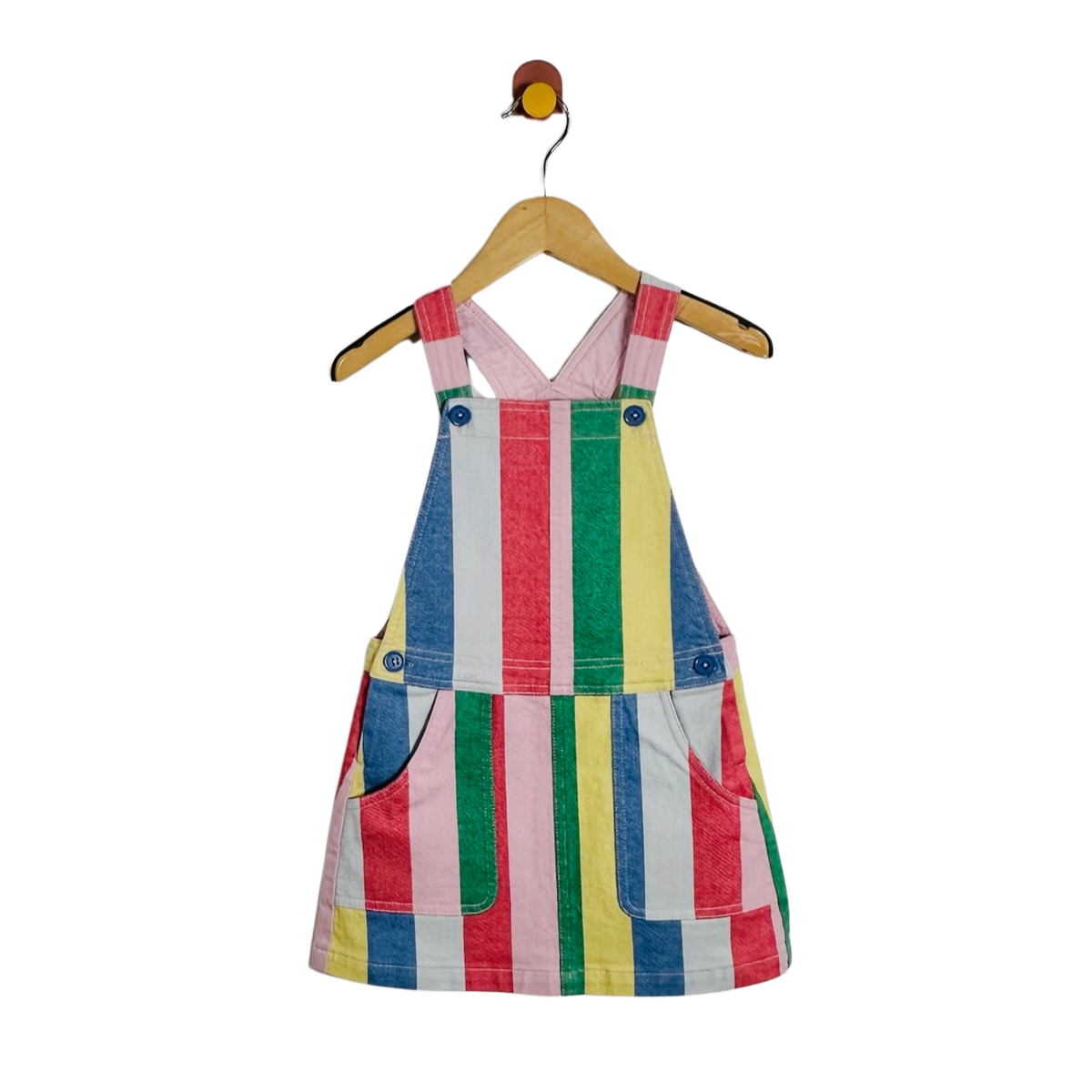 A children's sleeveless pinafore-style dress with colorful vertical stripes in pink, blue, green, yellow, and white, hanging on a wooden hanger against a plain white background.