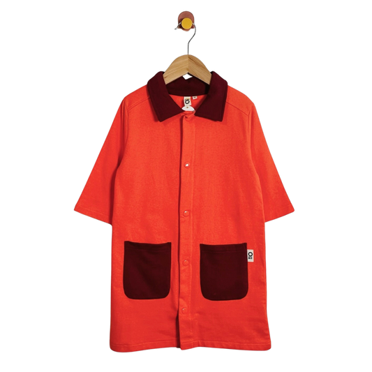 A short-sleeve button-front overshirt in bright orange corduroy with contrasting dark burgundy corduroy collar and pockets, hanging on a wooden hanger against a plain white background.