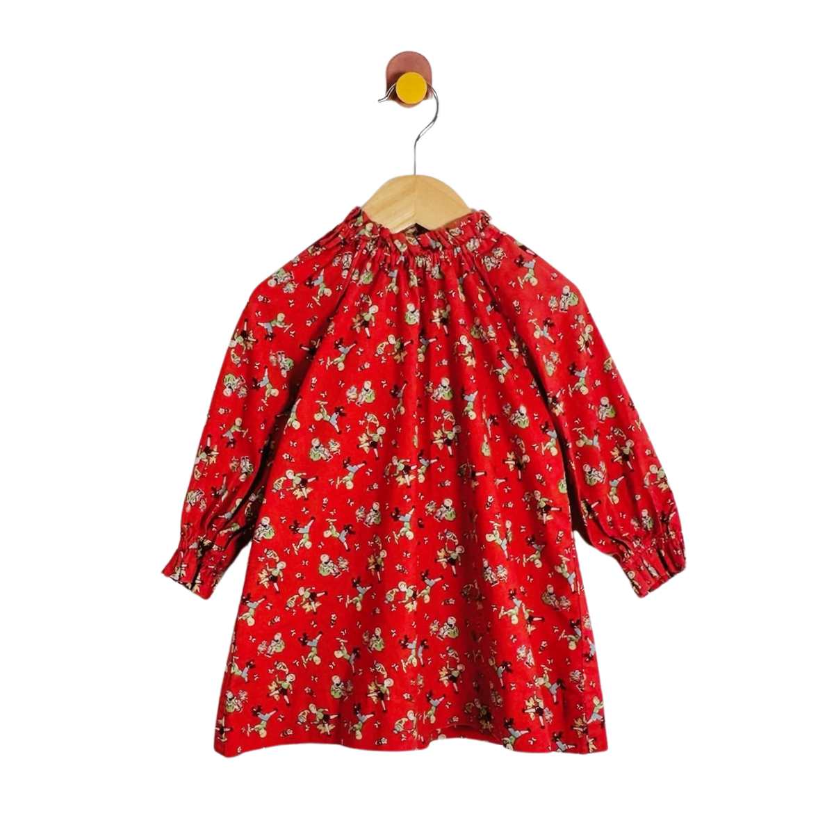 A red long-sleeve blouse with a dense small print, hanging on a wooden hanger against a plain white background.