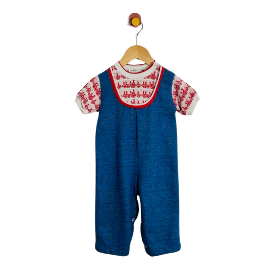 A baby short-sleeve overall romper in blue denim-like fabric, featuring a white embroidered yoke with red trim and matching red-and-white embroidered sleeves, hanging on a wooden hanger against a plain white background.