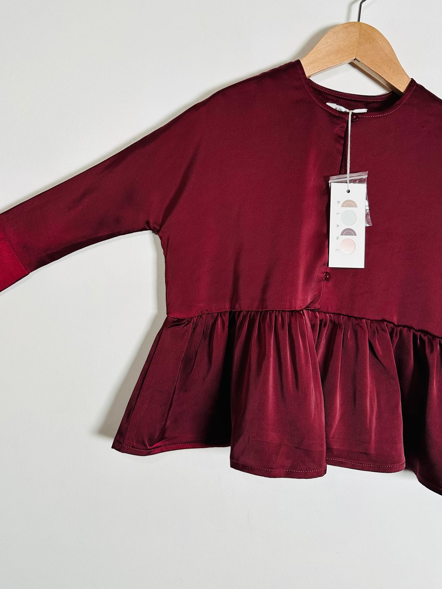 Maroon blouse with a tag on a white background