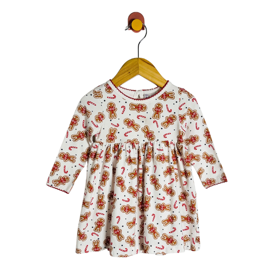 Children's dress with gingerbread pattern on a hanger against a white background