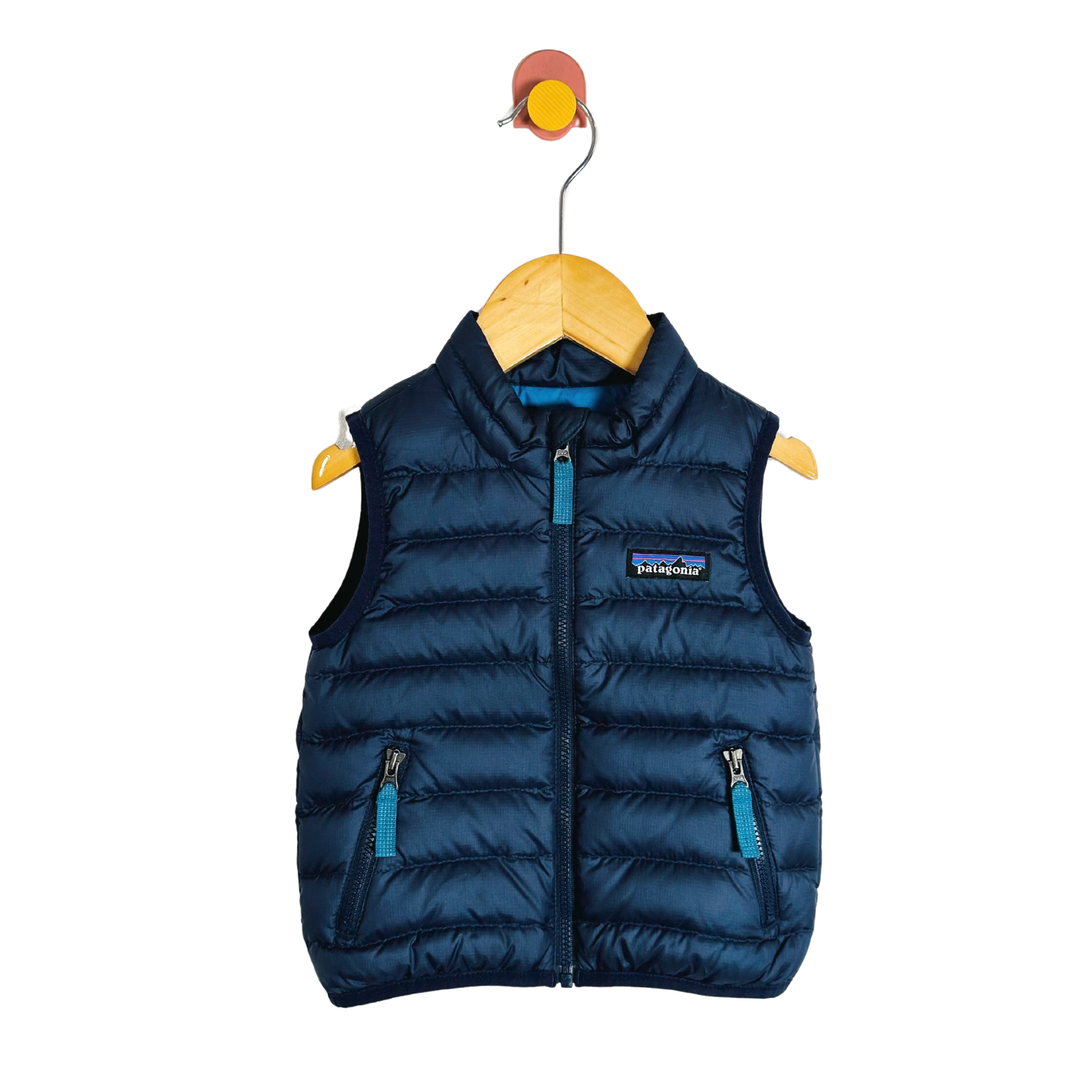 Blue puffer vest on a wooden hanger with a white background