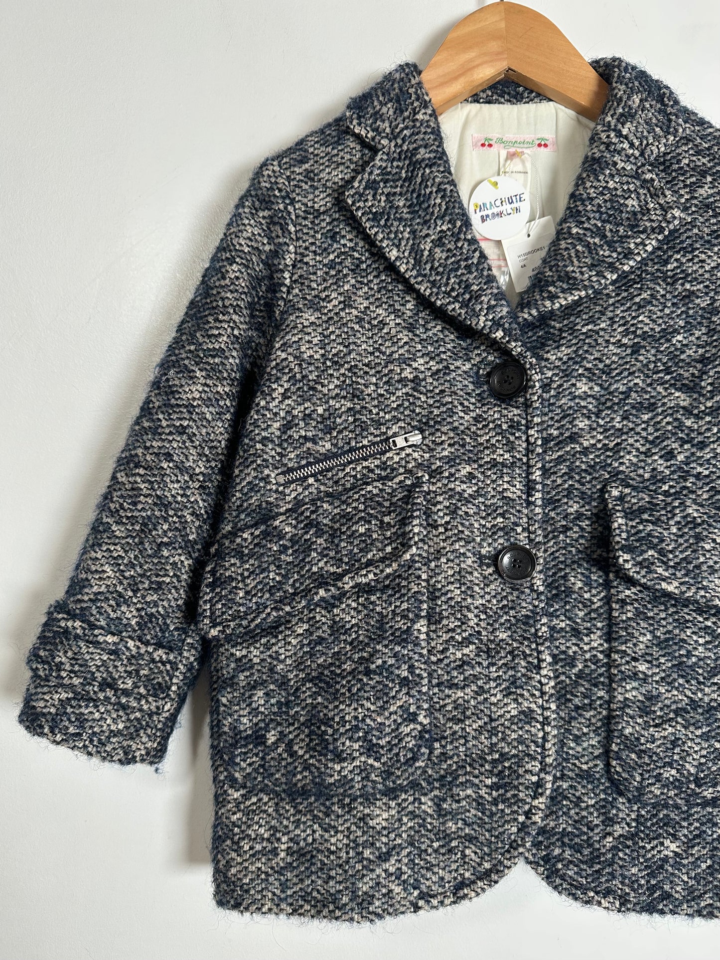 Children's dark gray textured coat on a hanger with a visible brand label.