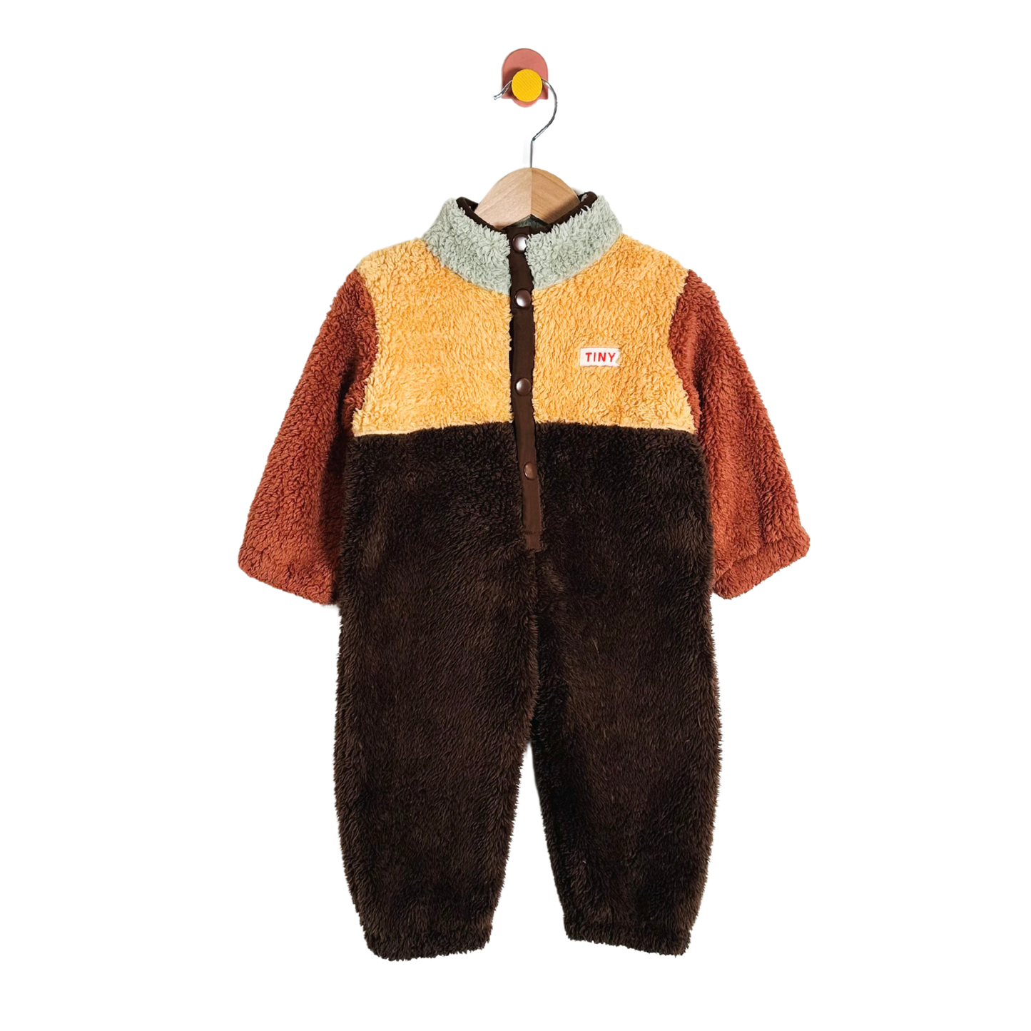 Children's multicolored fleece onesie on a hanger against a white background